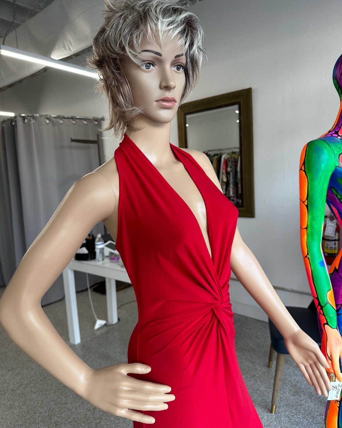 Mannequin in a red halter dress with a knot at the waist, next to a mannequin painted in bright colors