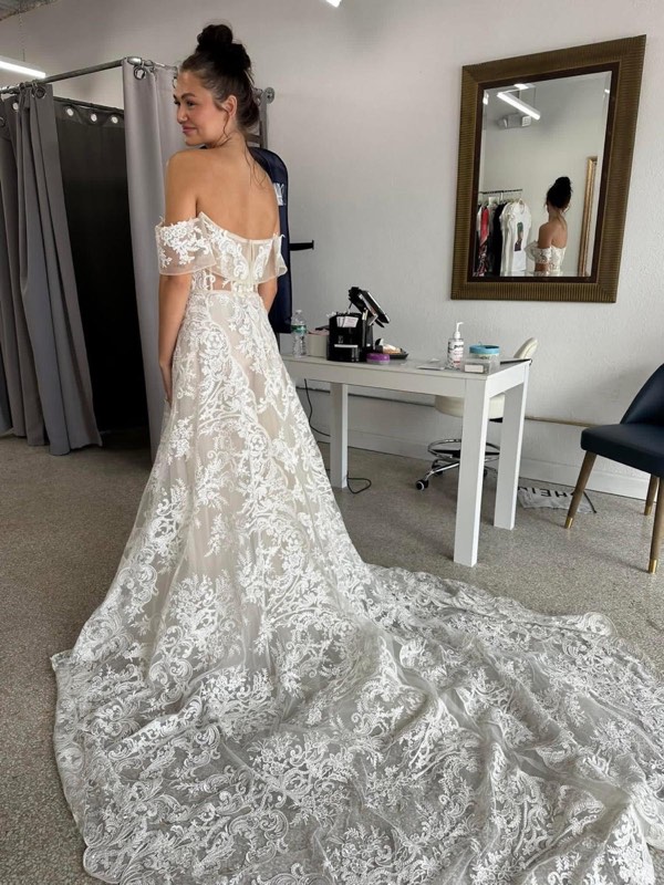 Lace wedding gown with a long train, fitted in the atelier