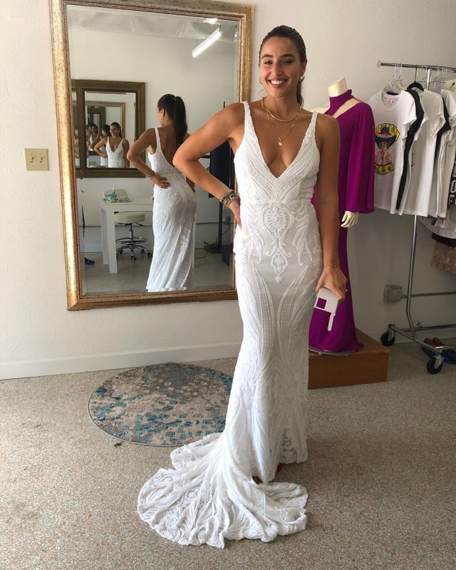 Bride in a V-neck sequin gown by the mirror